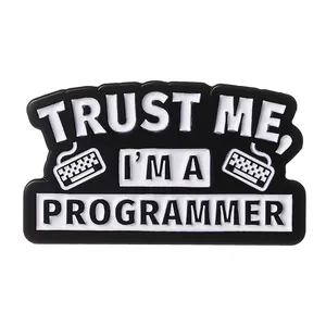 Macro shot of trust me I am a programmer enamel pin with keyboard icons