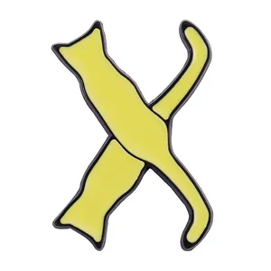 Close-up of yellow cat silhouette badge forming the letter X with smooth metal edges