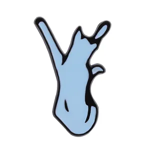 Detail of light blue enamel cat badge with black outlines and glossy metal finish