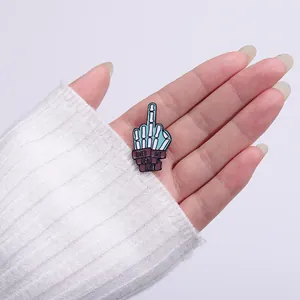 Enamel skull gesture brooch featuring Over My Dead Body slogan on a mint green metal pin
