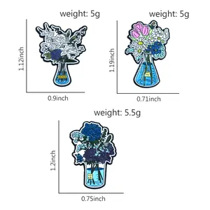 Three artistic floral enamel pins featuring lilies and tulips in decorative vases