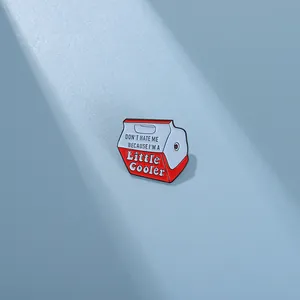 Macro shot of a red and white mini cooler enamel pin with Don't Hate Me slogan
