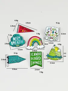 Detail of inspirational enamel pins with motivational quotes like I CAN DO HARD THINGS