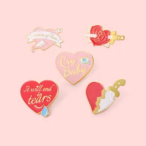Macro view of five pink enamel alloy brooches featuring heart and dagger creative designs