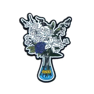 Close-up of a floral vase shoe charm with white lilies and blue hydrangeas details
