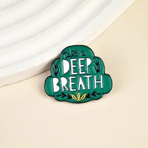 Green bush enamel pin with 'take a DEEP BREATH' text on minimalist leather background