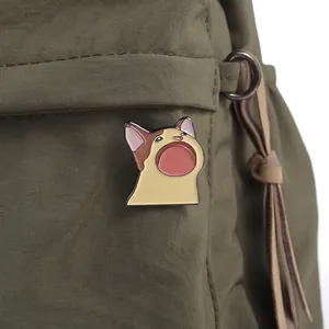 Gros plan du pin's émaillé Pop Cat représentant le chat sur un sac en toile vert