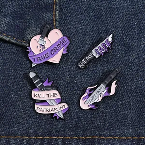 Dettaglio di quattro spilli creativi in smalto a pugnale con motivi a cuore su denim