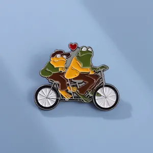 Détail du pin's émaillé Grenouille et Crapaud sur un tandem avec un cœur rouge