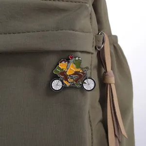 Détail du pin's émaillé Grenouille et Crapaud sur un sac à dos en toile vert foncé