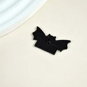 Detailed back view of a black bat metal brooch with secure pin and textured surface
