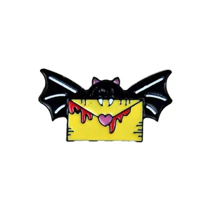 Halloween metal enamel pin featuring a black bat holding a yellow heart envelope