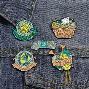 Détail de pins en émail mignons motif chat et tricot sur une veste en jean bleue