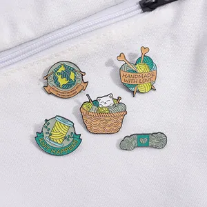 Détail de 5 épinglettes en émail tricoté avec chats et pelotes sur sac en toile