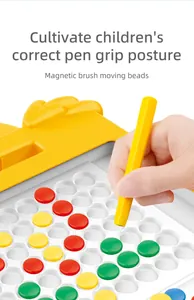 Close-up of magnetic pen guiding colorful beads on a yellow educational drawing board