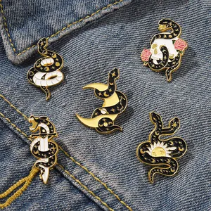 Set of 5 mystical gothic snake enamel pins with crescent moon and skull designs on denim