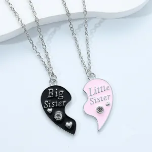 Detail of Big Little Sister split heart necklaces with pink and black enamel and crystals