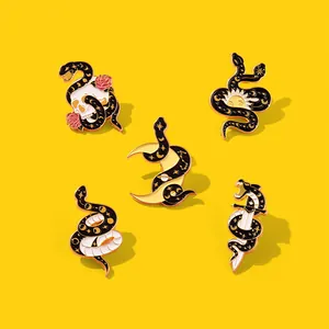 Detail of five gothic snake enamel pins with skull, moon, and dagger on yellow background