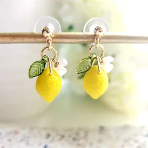 Yellow lemon drop earrings with green leaf and white flower details on gold hooks