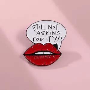 Detail showing enamel pin with red lips and Still Not Asking For It message text
