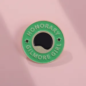 Détail du pin's émaillé vert avec bords dorés et graphique de tasse de café