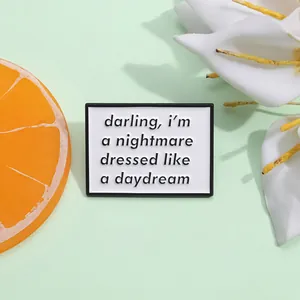 Minimalist enamel pin with 'darling, i'm a nightmare' text on light green background