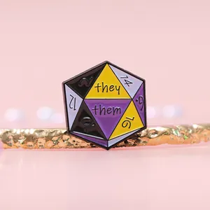 Detail of Non-binary Pride dice enamel pin featuring they/them pronouns on golden stand
