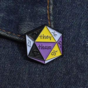 Macro detail of they/them pronoun D20 dice enamel pin on blue denim fabric