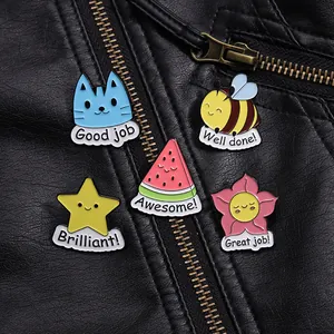 Close-up of five enamel animal and star pins with motivational text on a leather jacket
