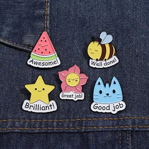 Detailed view of five enamel animal and star badges with motivational words on denim fabric