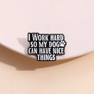 Détail du pin's en émail noir avec texte I WORK HARD SO MY DOG CAN HAVE NICE THINGS