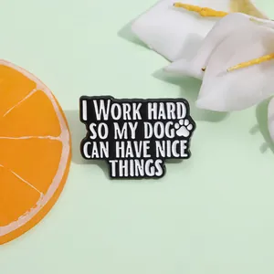 Détail d'un pin's en émail avec empreinte de patte de chien et texte sur fond vert