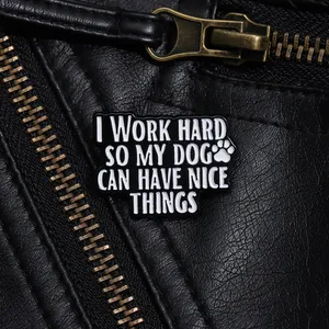 Détail macro du pin's émaillé avec citation de chien sur texture de veste en cuir