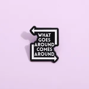 Macro detail of enamel pin badge with What Goes Around Comes Around quote
