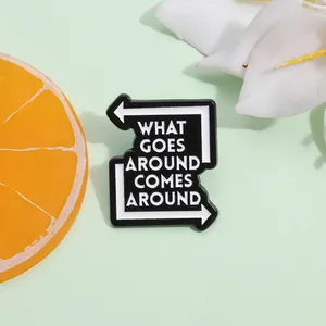 Enamel pin with What Goes Around Comes Around quote on green backdrop with flowers