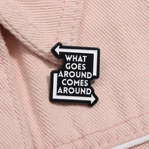 Enamel letter brooch with 'What Goes Around Comes Around' quote on denim fabric
