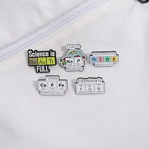 Set of chemistry enamel pins with periodic table elements on white canvas bag detail