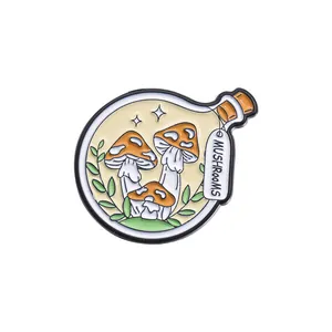 Detail of an enamel pin featuring orange mushrooms inside a glass bottle with star accents
