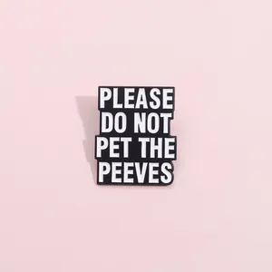 Macro detail of enamel brooch with funny slogan PLEASE DO NOT PET THE PEEVES on pink background