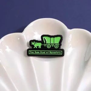 Macro shot of pixel art enamel pin on shell tray showing retro video game wagon graphics