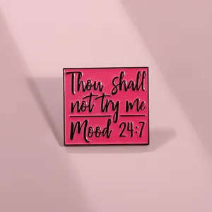 Detail of pink enamel badge with black text Thou shall not try me Mood 24:7 engraving
