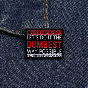 Detailaufnahme der Emaille-Anstecknadel mit Spruch auf dunklem Jeansstoff-Hintergrund