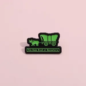 Detail of pixel art enamel pin featuring an Oregon Trail wagon and dysentery text