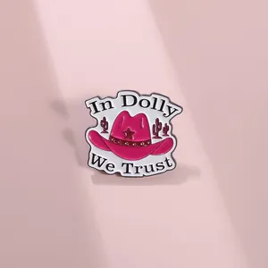 Detailed view of pink enamel cowboy hat pin with cactus and In Dolly We Trust slogan