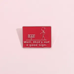 Detail of red enamel matchman brooch with humorous Well that's not a good sign text