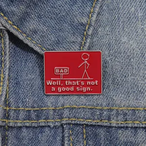 Macro detail of red enamel pin with stickman and 'Well, that's not a good sign' text