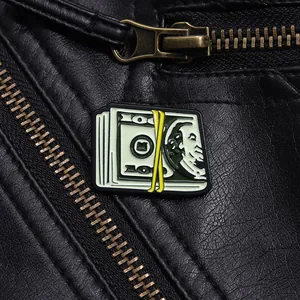 Macro d'un pin's dollar en émail sur veste en cuir noir avec détail de fermeture éclair