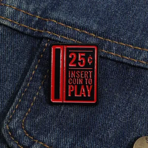 Dettaglio della spilla smaltata arcade retrò su denim con fessura rossa da 25 cent