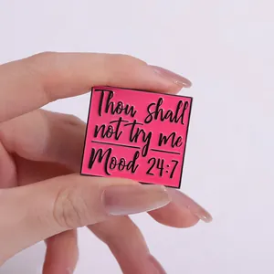 Close-up of pink square enamel pin with 'Thou shall not try me Mood 24:7' text detail