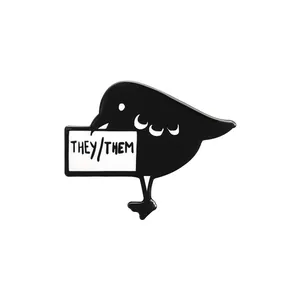 Minimalist black bird enamel pin with They/Them pronoun tag in polished zinc alloy